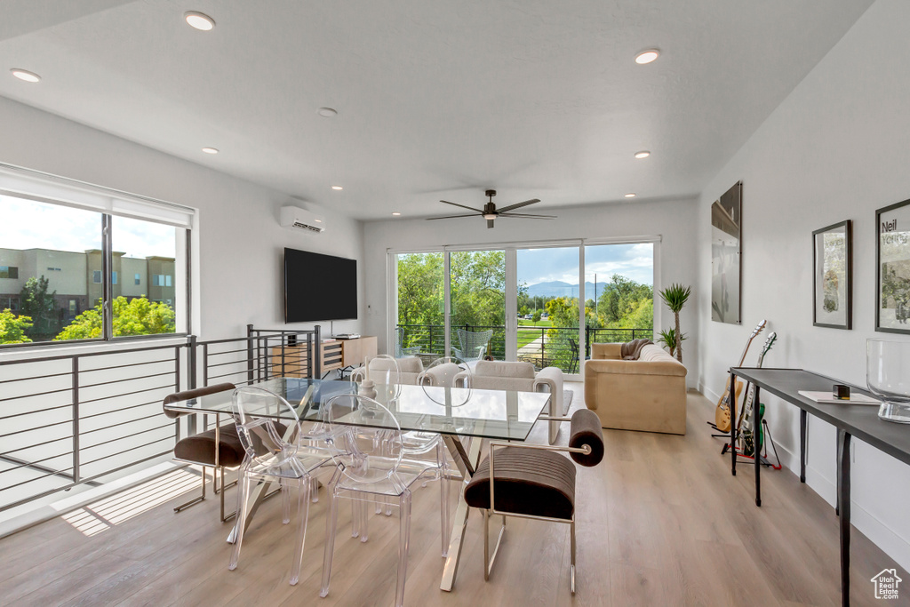 Dining area with a wall mounted AC, light wood-style floors, plenty of natural light, a ceiling fan, and recessed lighting