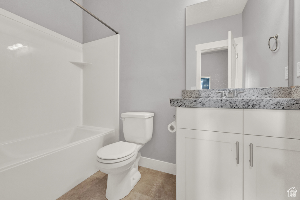 Bathroom with vanity, washtub / shower combination, and tile patterned flooring