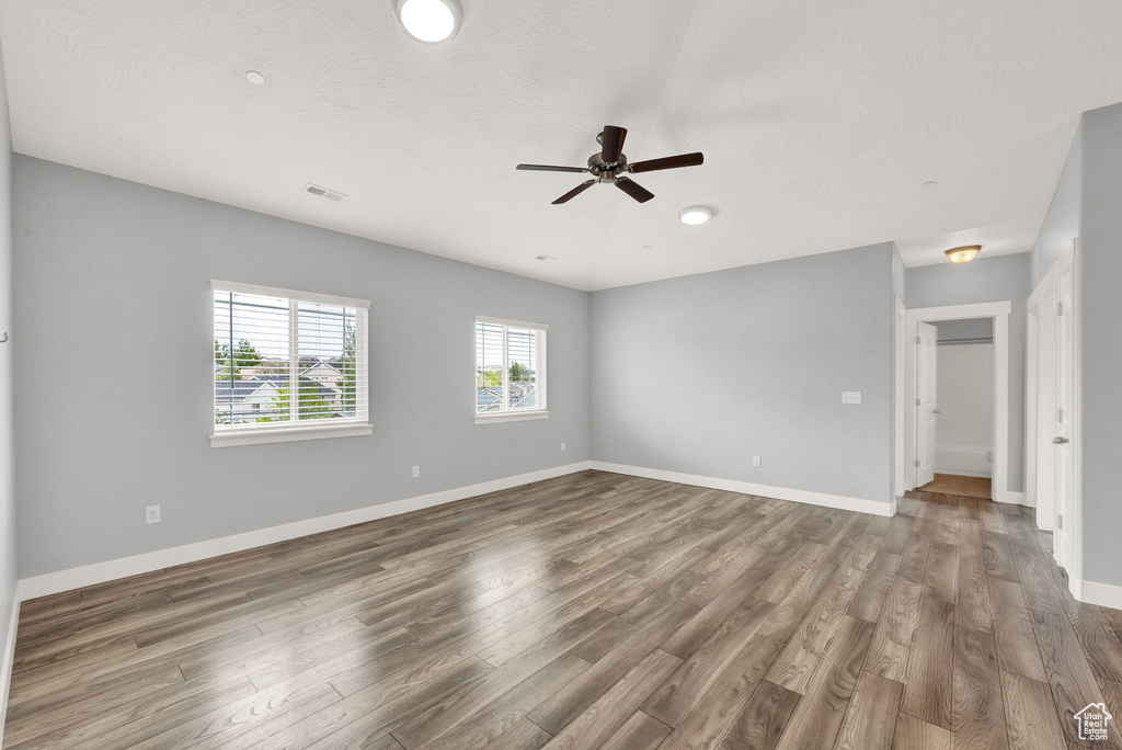 Empty room featuring ceiling fan, wood finished floors, and recessed lighting
