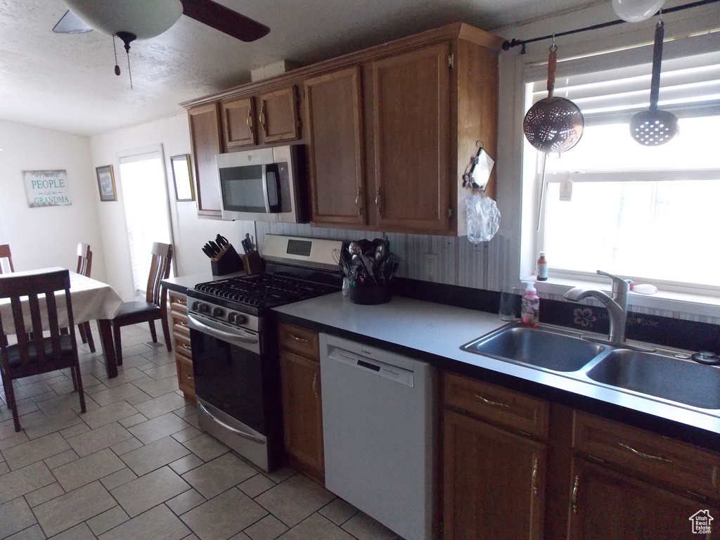 Kitchen with appliances with stainless steel finishes and ceiling fan