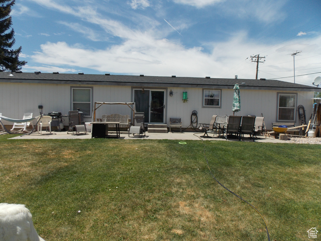 Back of property featuring a patio area and a lawn