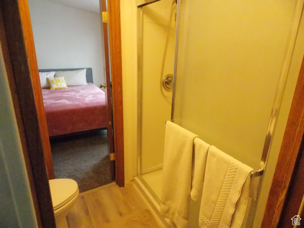 Ensuite bathroom featuring a stall shower and wood finished floors