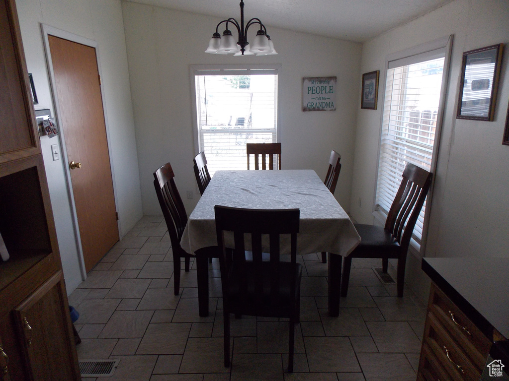 Dining space featuring healthy amount of natural light, a chandelier, and lofted ceiling