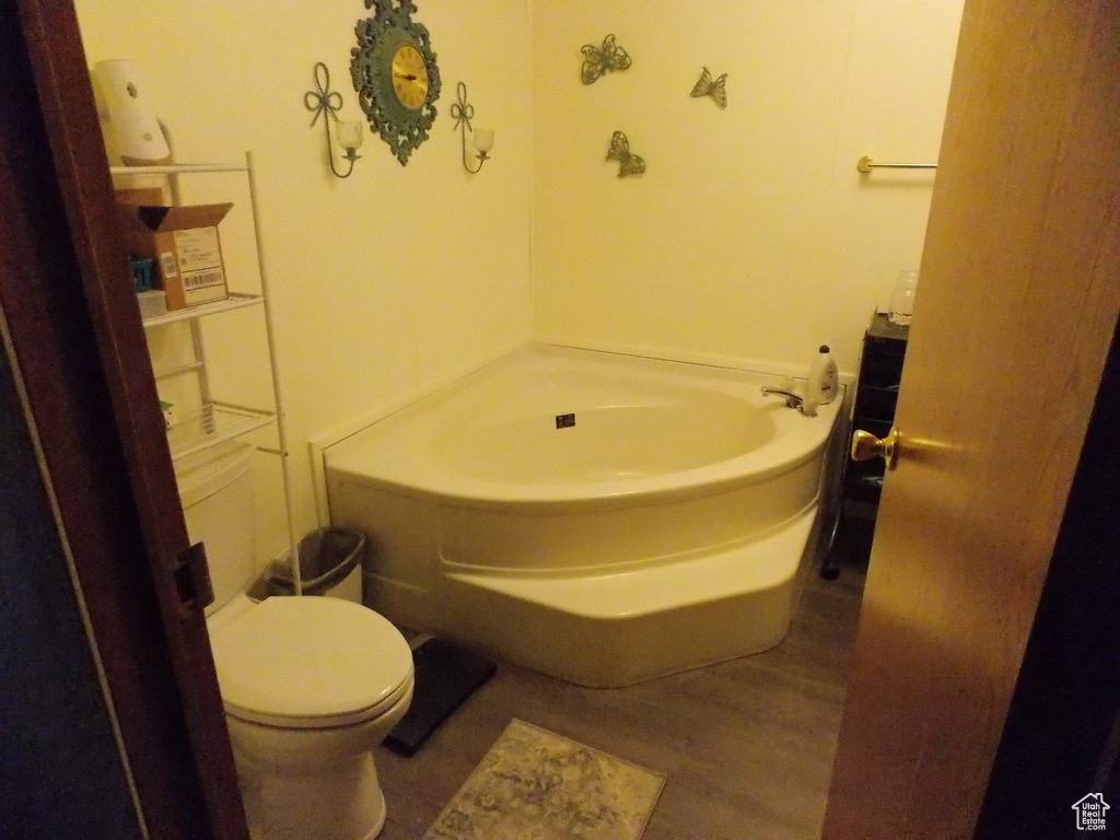 Bathroom with wood finished floors and a garden tub