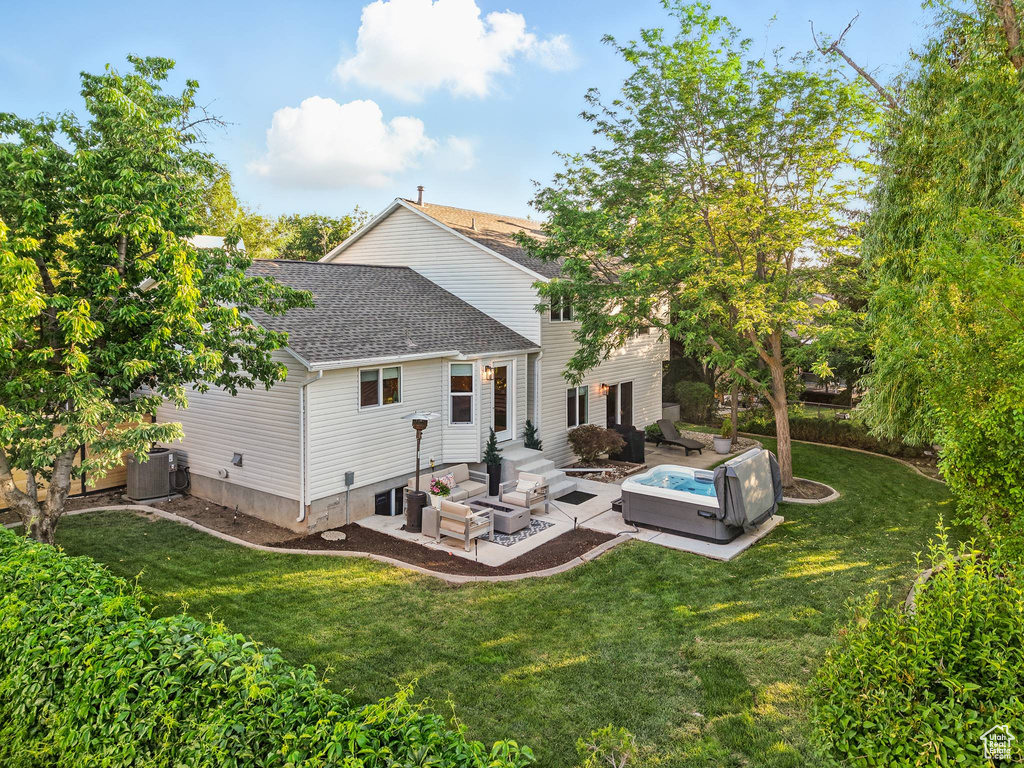 Rear view of property with an outdoor hangout area, a shingled roof, a patio, and a lawn