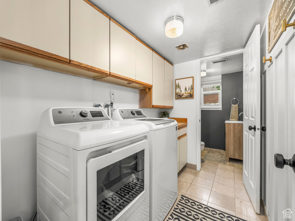 Laundry room featuring cabinet space and independent washer and dryer