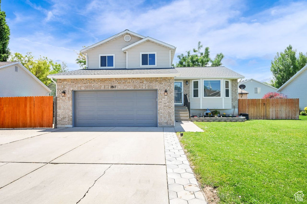 View of front of home with brick siding, driveway, a garage, and a shingled roof