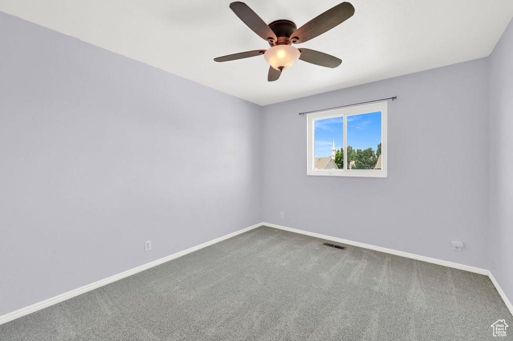 Empty room featuring carpet and a ceiling fan