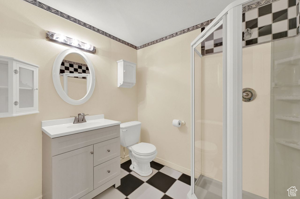 Bathroom with tile patterned floors, vanity, and a stall shower