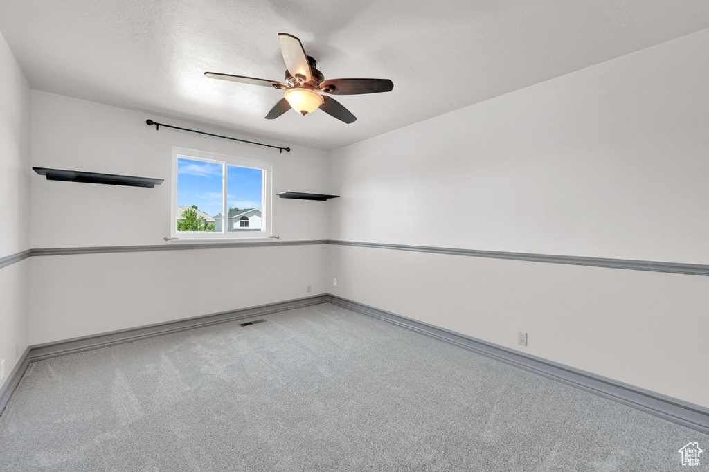 Spare room featuring a ceiling fan and carpet flooring