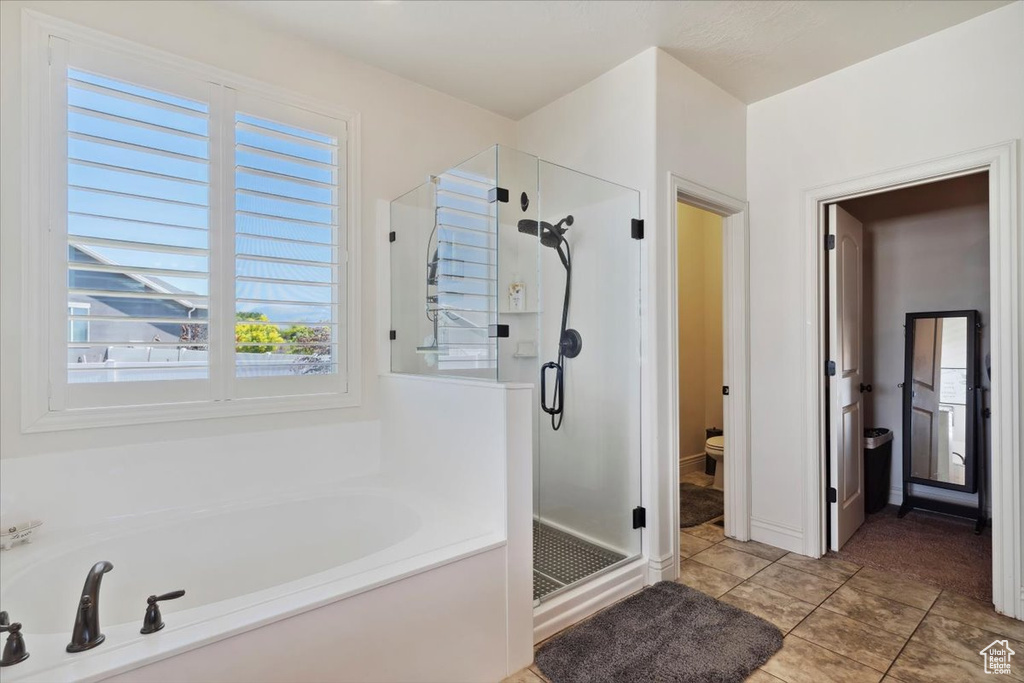 Full bath with a stall shower, a bath, and tile patterned flooring