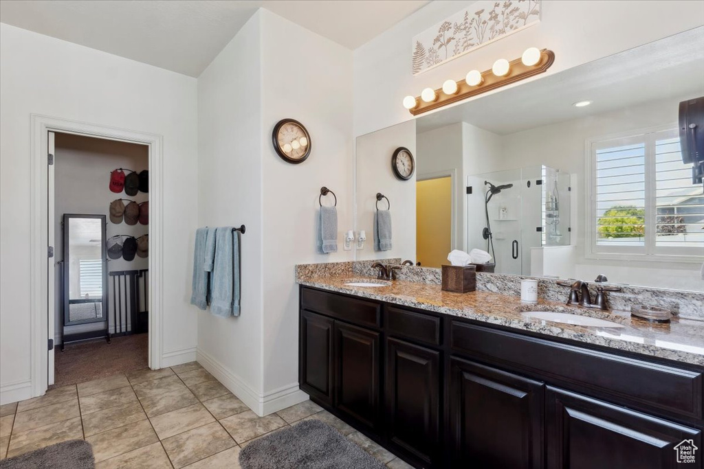 Bathroom featuring a stall shower and double vanity