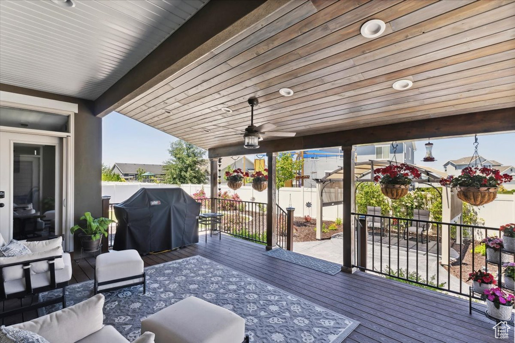 Deck featuring a fenced backyard, a ceiling fan, and grilling area