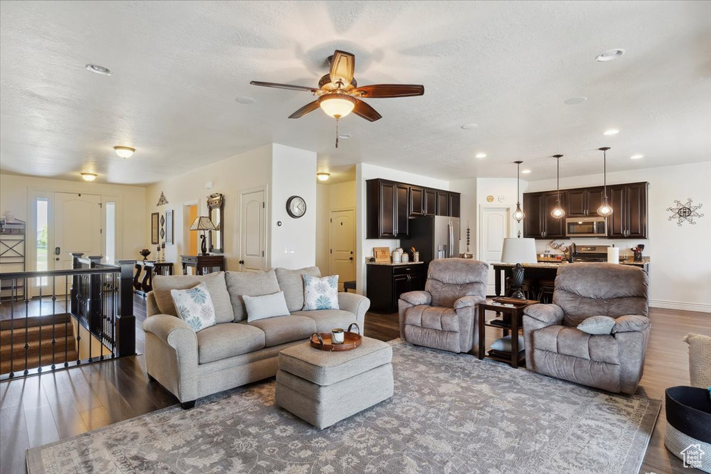 Living area featuring wood finished floors, a ceiling fan, and recessed lighting