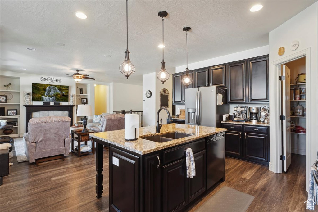 Kitchen with stainless steel fridge, dishwasher, dark wood finished floors, open floor plan, and pendant lighting