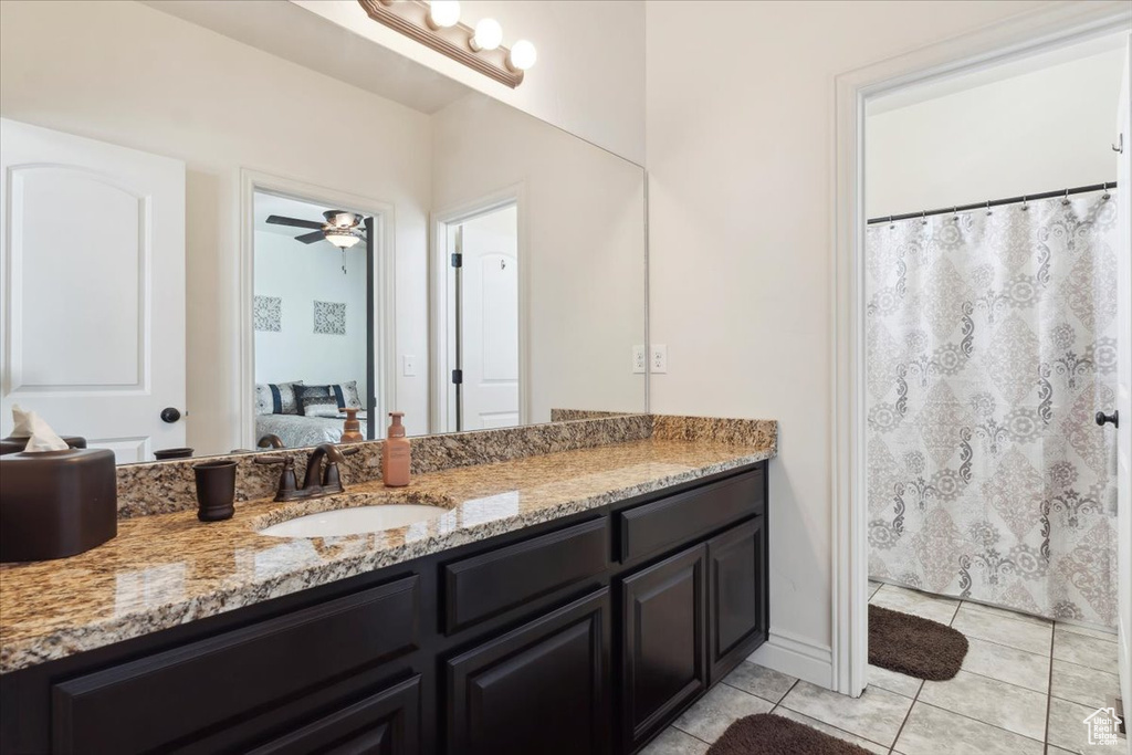 Ensuite bathroom with vanity, tile patterned floors, and a ceiling fan