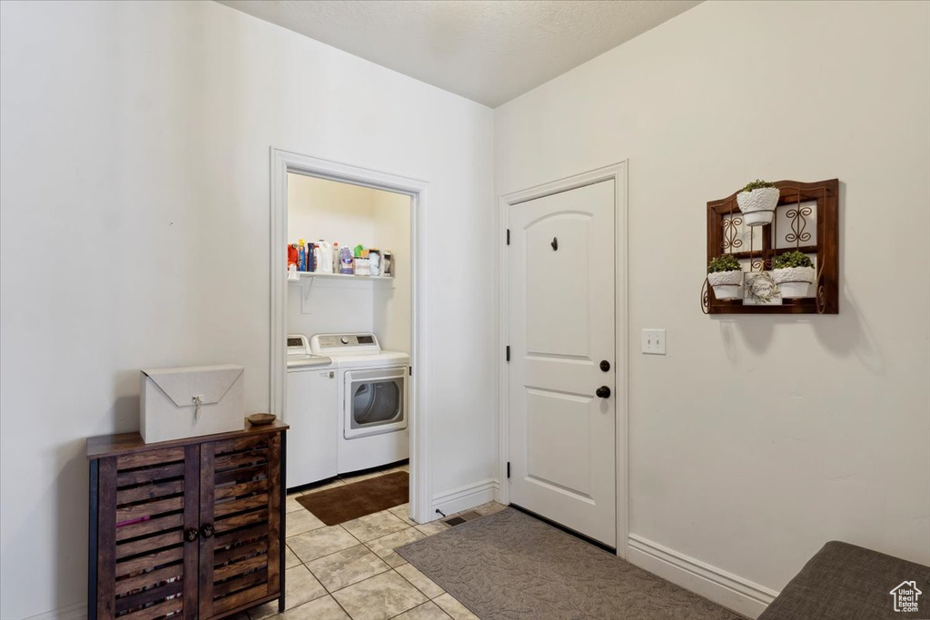 Foyer featuring washing machine and dryer and light tile patterned floors