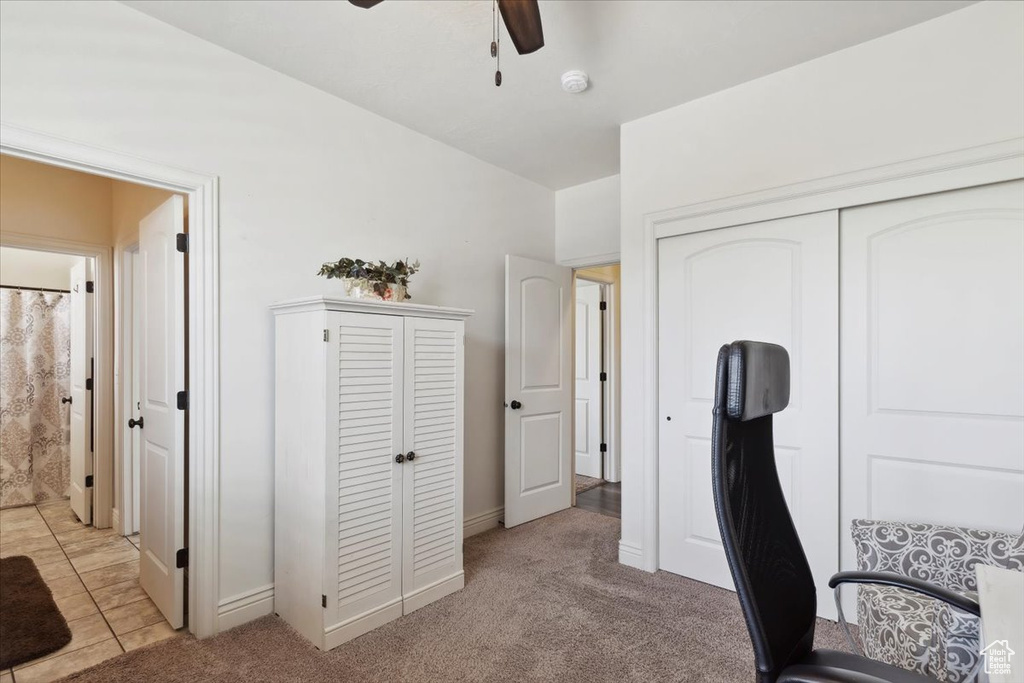 Office area with a ceiling fan and light carpet