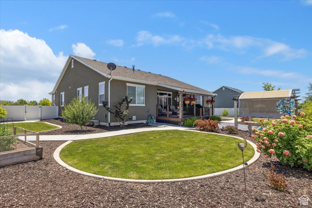 Back of house with stucco siding and a garden