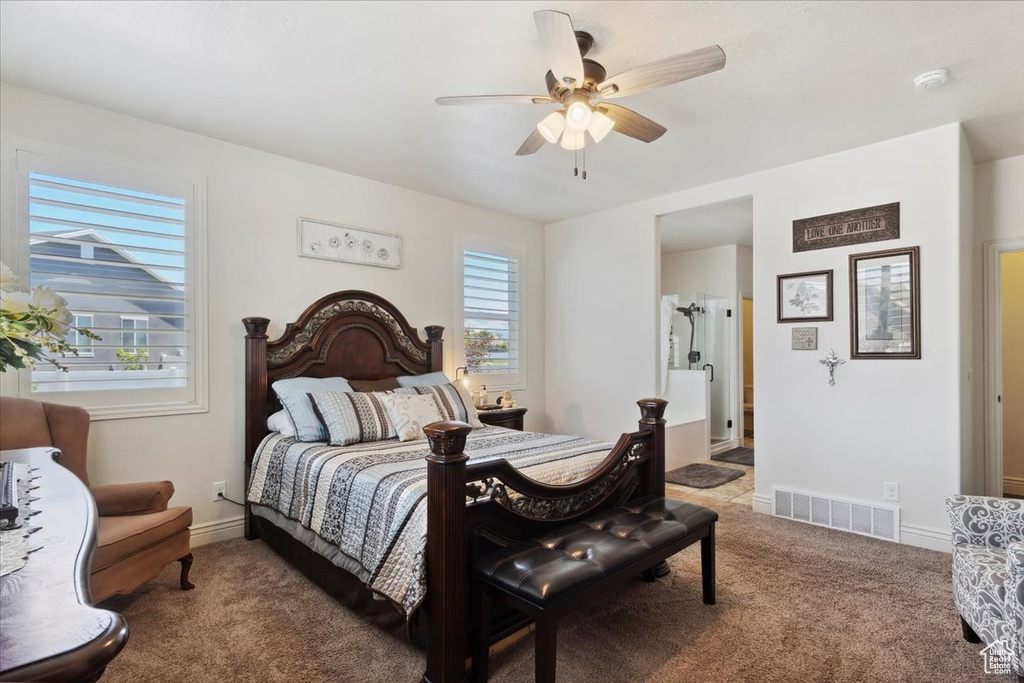 Carpeted bedroom with multiple windows and a ceiling fan