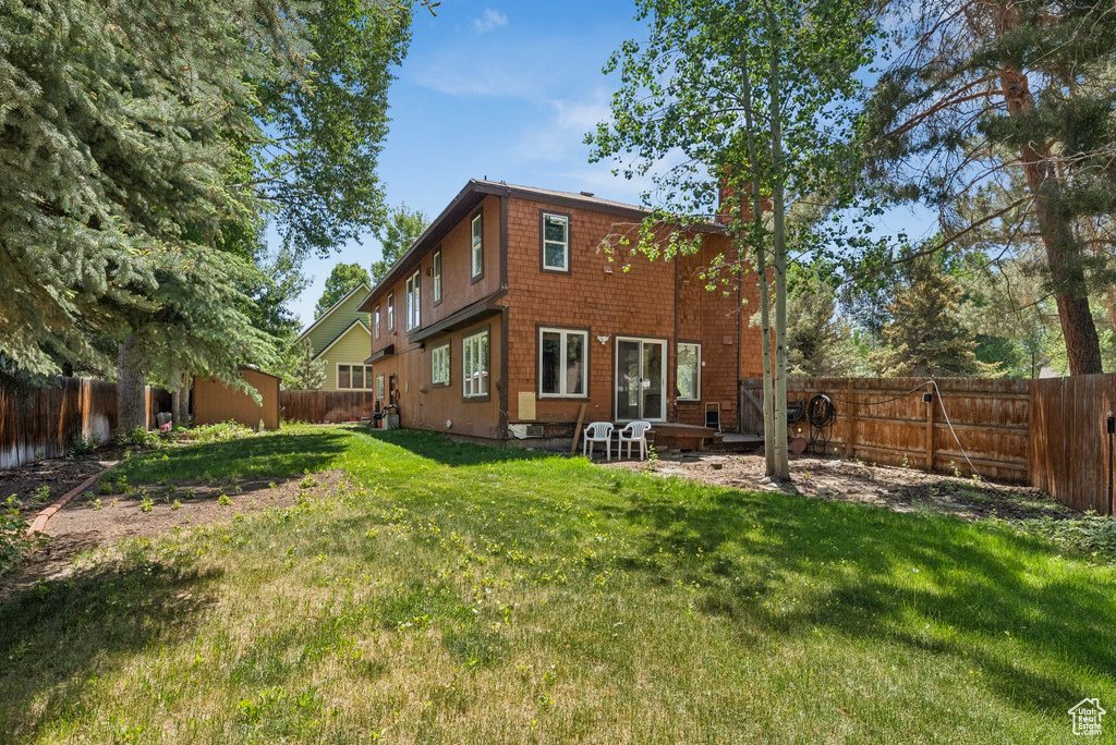 Back of property featuring a chimney and a fenced backyard