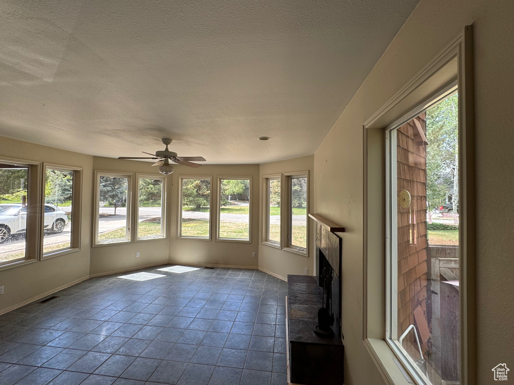 Unfurnished sunroom featuring baseboards and tile patterned floors
