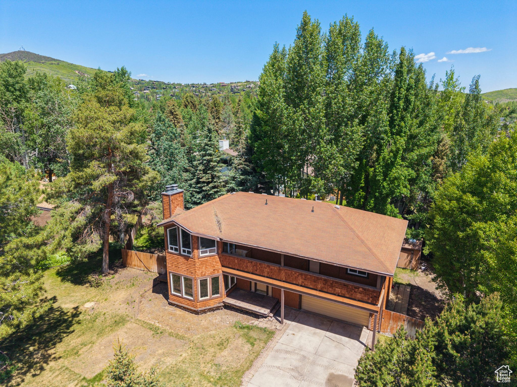 Aerial view of property and surrounding area featuring a forest