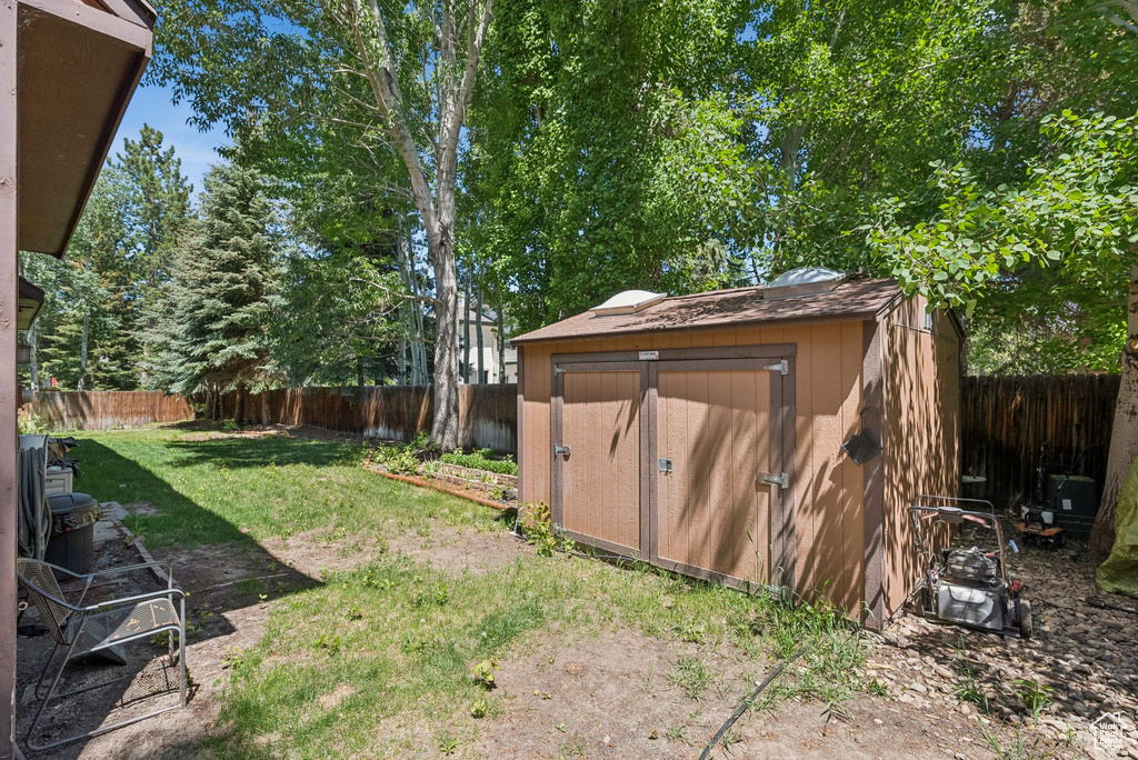Fenced backyard featuring a storage shed