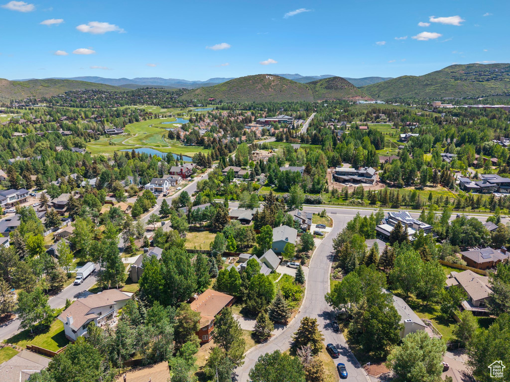 Aerial view of property and surrounding area with a water and mountain view and nearby suburban area