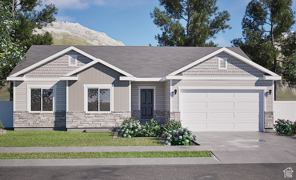 Craftsman-style house with stone siding, driveway, an attached garage, and a mountain view