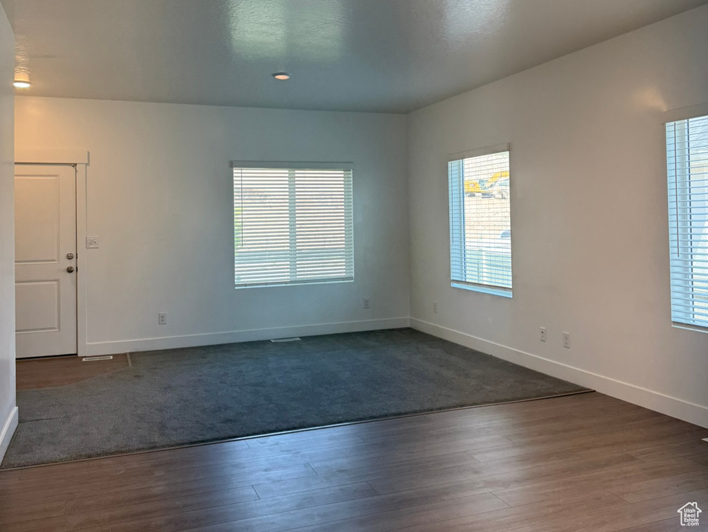 Unfurnished room with dark wood finished floors, baseboards, a textured ceiling, and recessed lighting