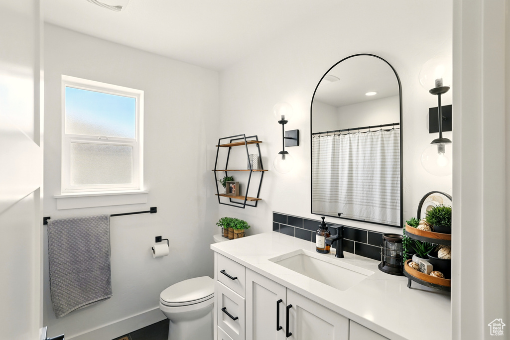 Full bath with vanity, backsplash, and a shower with shower curtain
