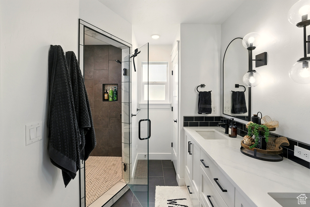 Bathroom with double vanity, a stall shower, and tile patterned flooring