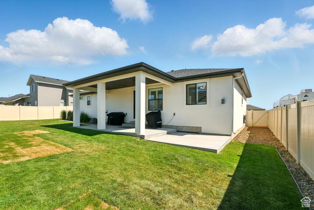 Back of house with a patio, stucco siding, and a fenced backyard