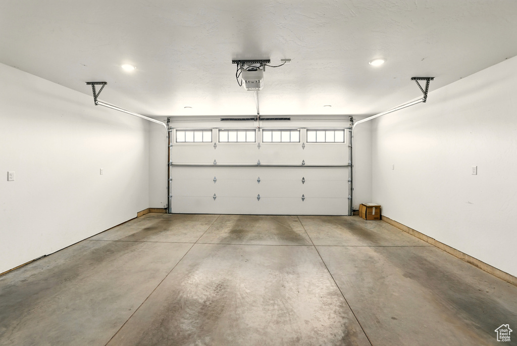 Garage with a garage door opener and baseboards
