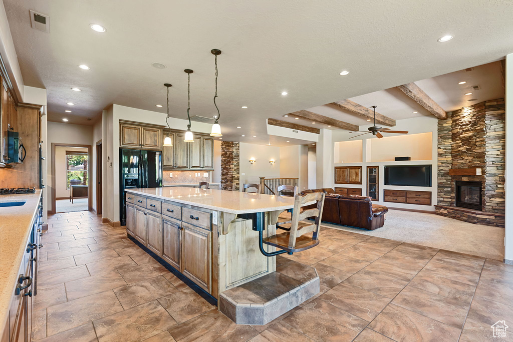 Kitchen with black appliances, recessed lighting, a ceiling fan, a breakfast bar, and light countertops