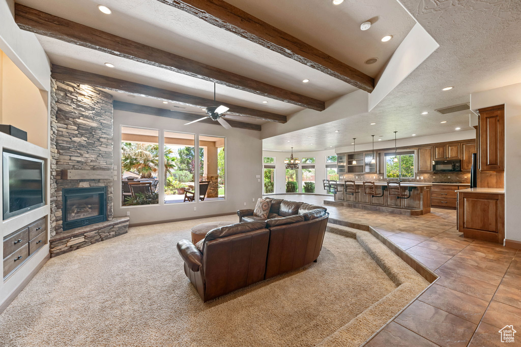 Living room with recessed lighting, a fireplace, beam ceiling, and a ceiling fan