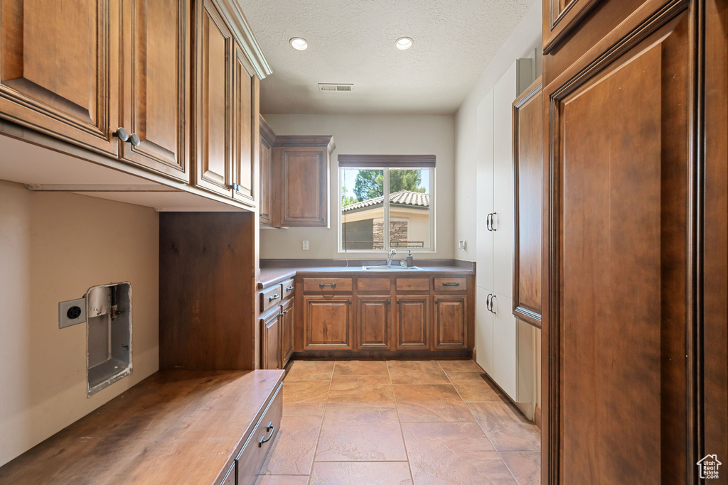 Washroom featuring cabinet space, hookup for an electric dryer, recessed lighting, and a textured ceiling