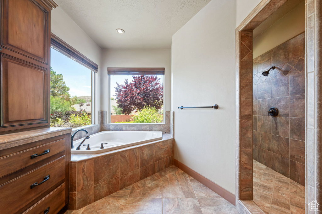 Full bath with a bath and tiled shower