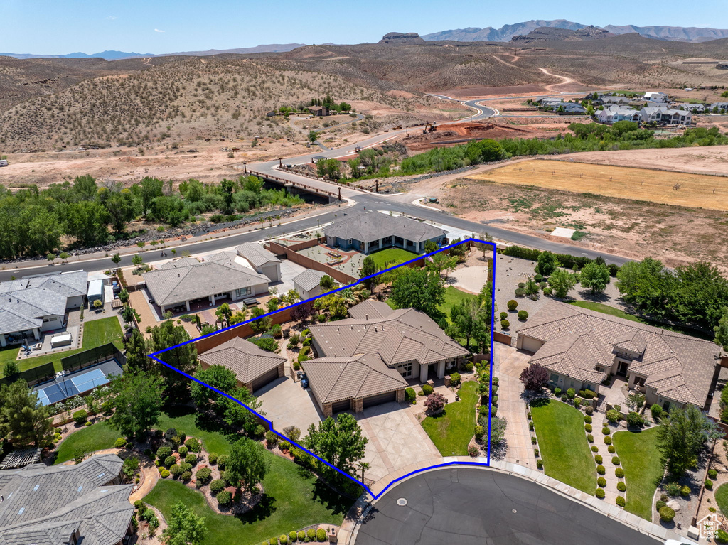 Aerial perspective of suburban area featuring a mountainous background and property boundaries highlighted