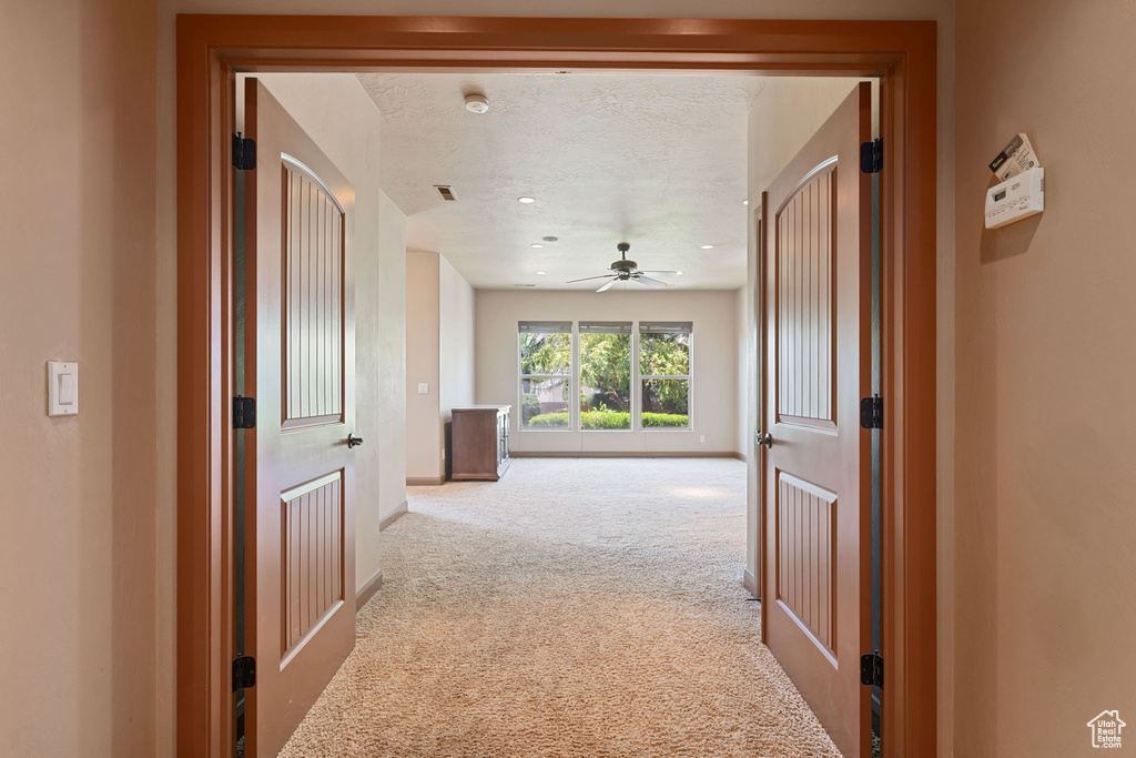 Corridor featuring carpet floors, a textured ceiling, and recessed lighting