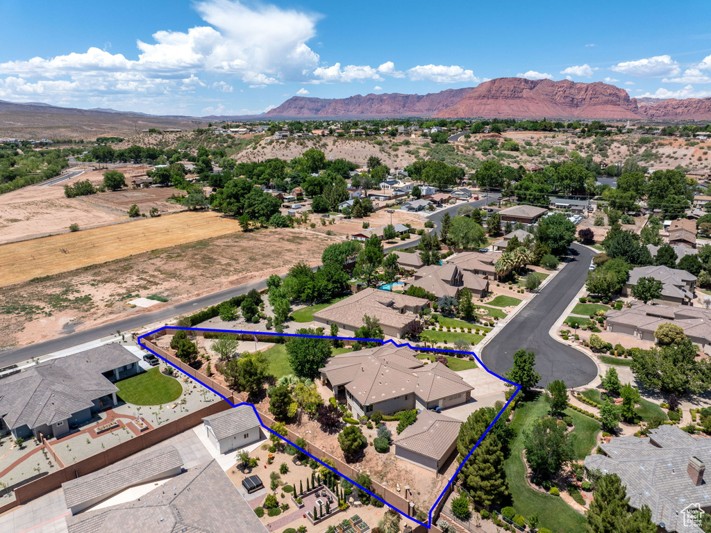 Aerial view of residential area with a mountain backdrop and property parcel outlined