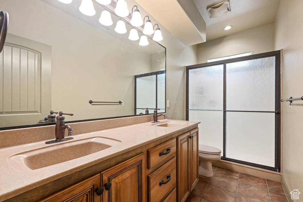 Full bath featuring a stall shower, double vanity, tile patterned flooring, and recessed lighting