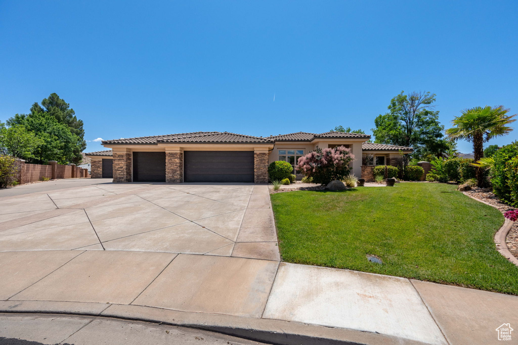 View of front of home with concrete driveway, a garage, a tile roof, stone siding, and stucco siding