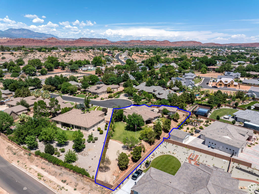 Aerial perspective of suburban area featuring a mountainous background and property parcel outlined