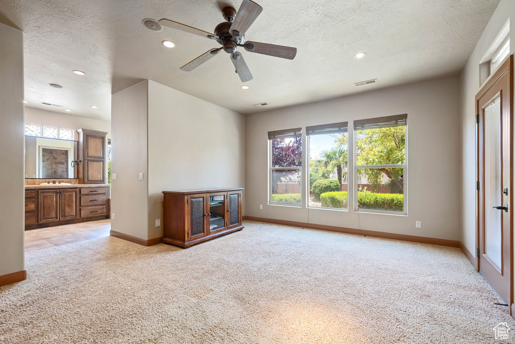 Unfurnished living room with light colored carpet, recessed lighting, a textured ceiling, and a ceiling fan