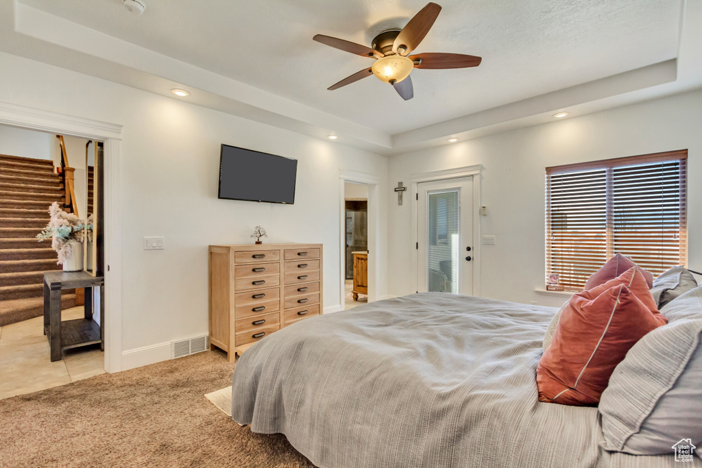 Bedroom featuring recessed lighting, light colored carpet, ceiling fan, a tray ceiling, and access to exterior