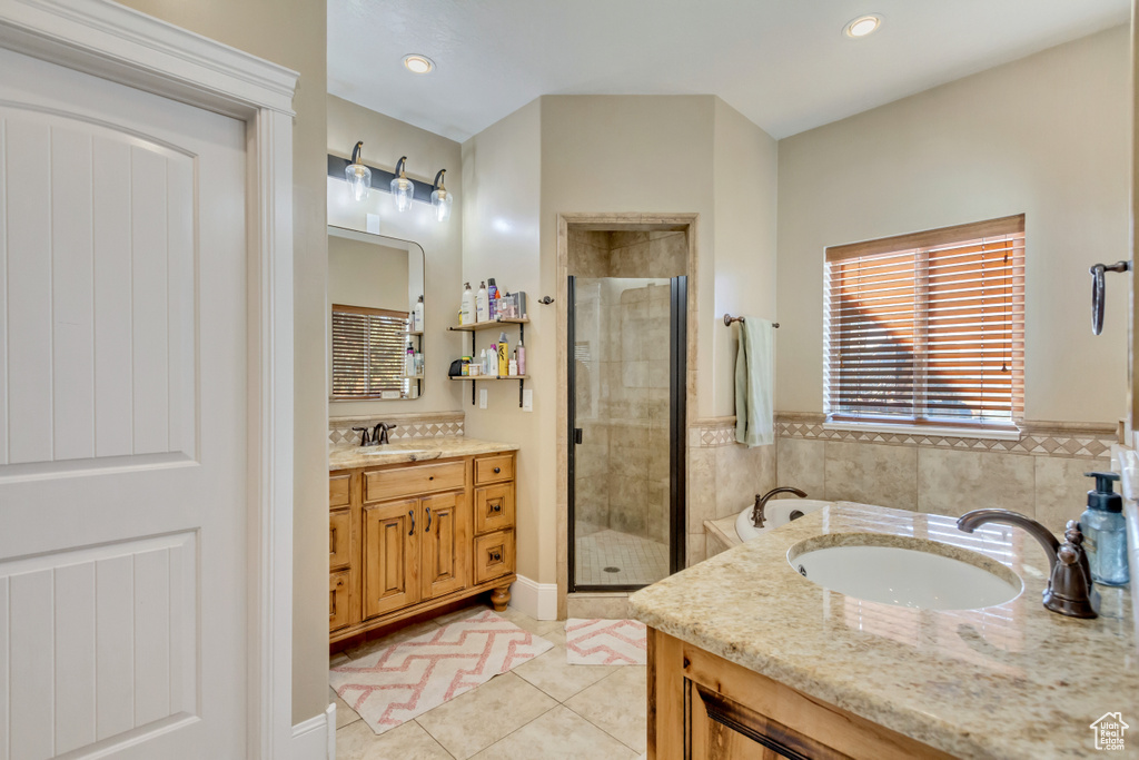 Bathroom featuring vanity, a shower stall, tile patterned floors, and a garden tub