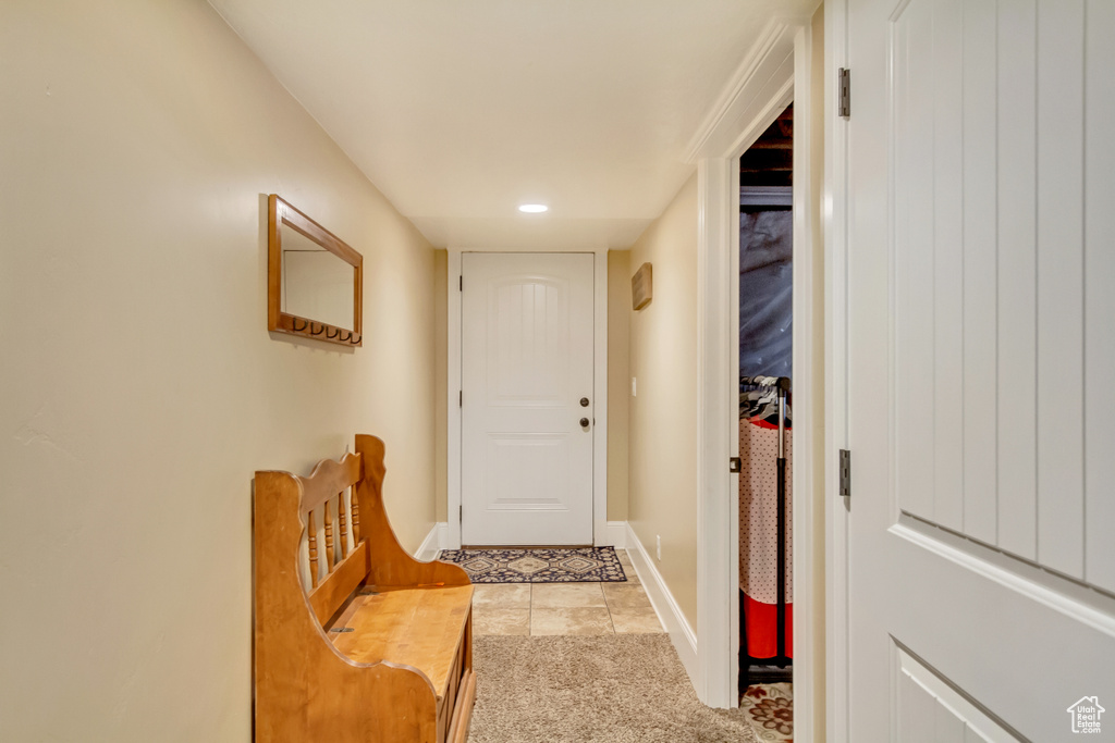 Doorway to outside featuring light carpet and light tile patterned floors