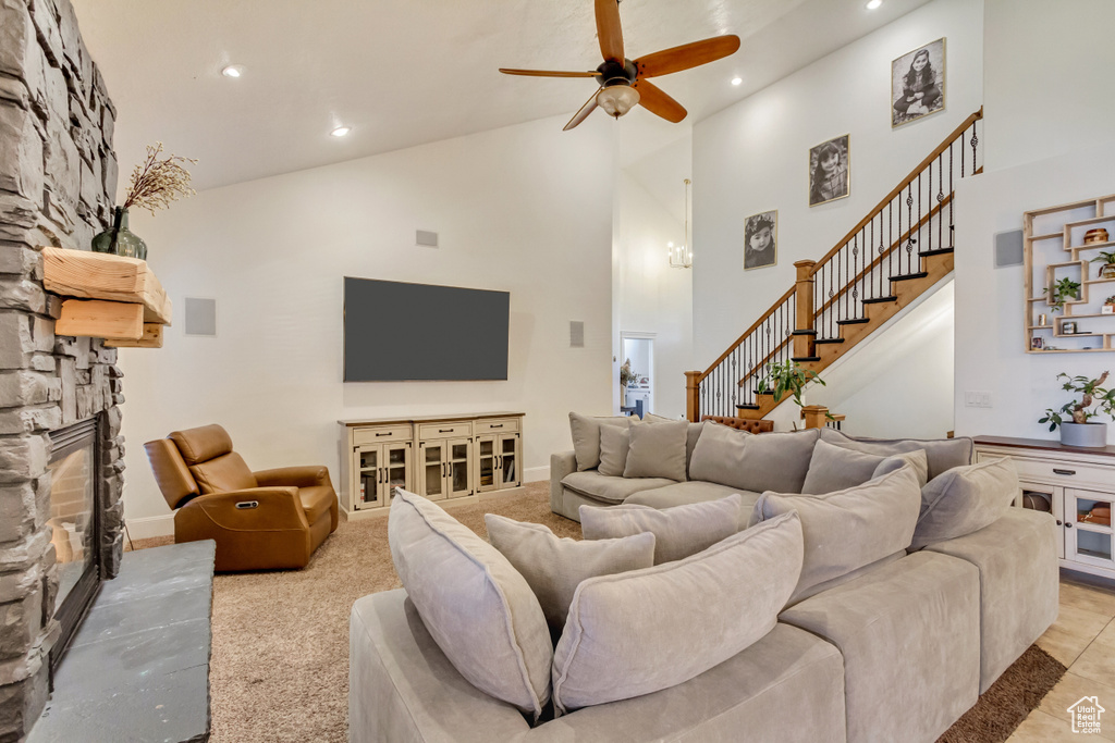 Living area featuring recessed lighting, high vaulted ceiling, a ceiling fan, a fireplace, and stairway